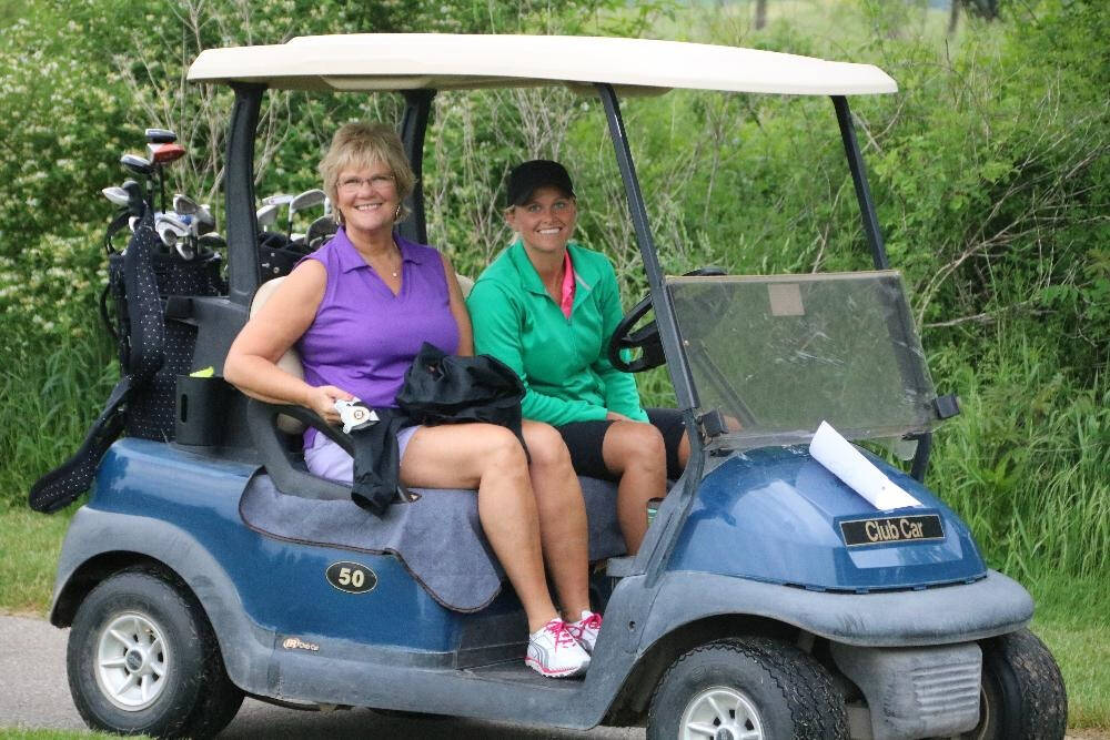 Two women in a golf cart